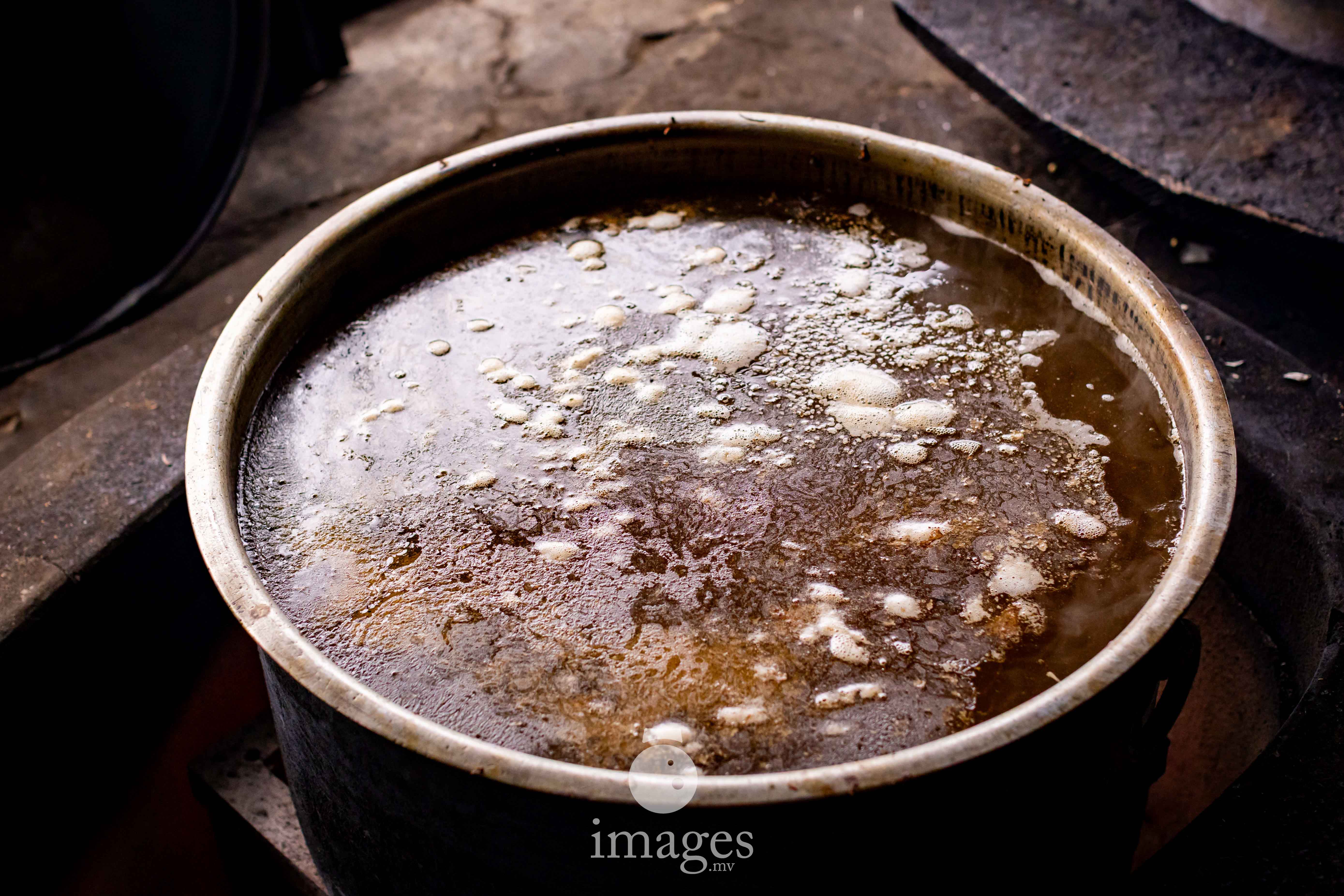 Tuna stock slowly reducing into rihaakuru over open fire.
