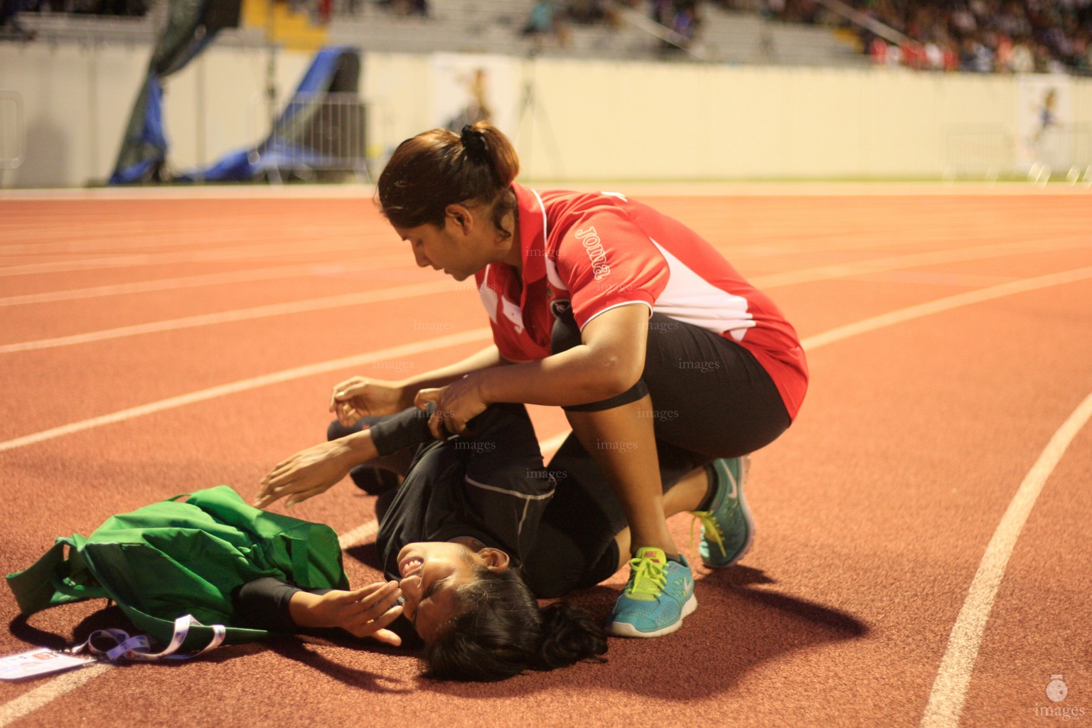 Umana Nooraddeen, Maldives Physio helps Afaa Ismail after she finishes the 200m heats Indian Ocean Island Games, La Reunion, Tuesday, August. 4, 2015.  (Images.mv Photo/ Hussain Sinan).